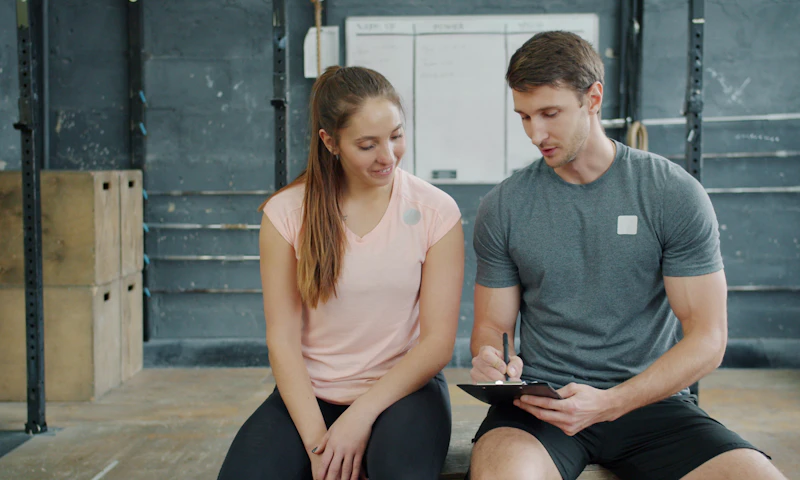 Éducateur sportif prenant des notes avec une pratiquante